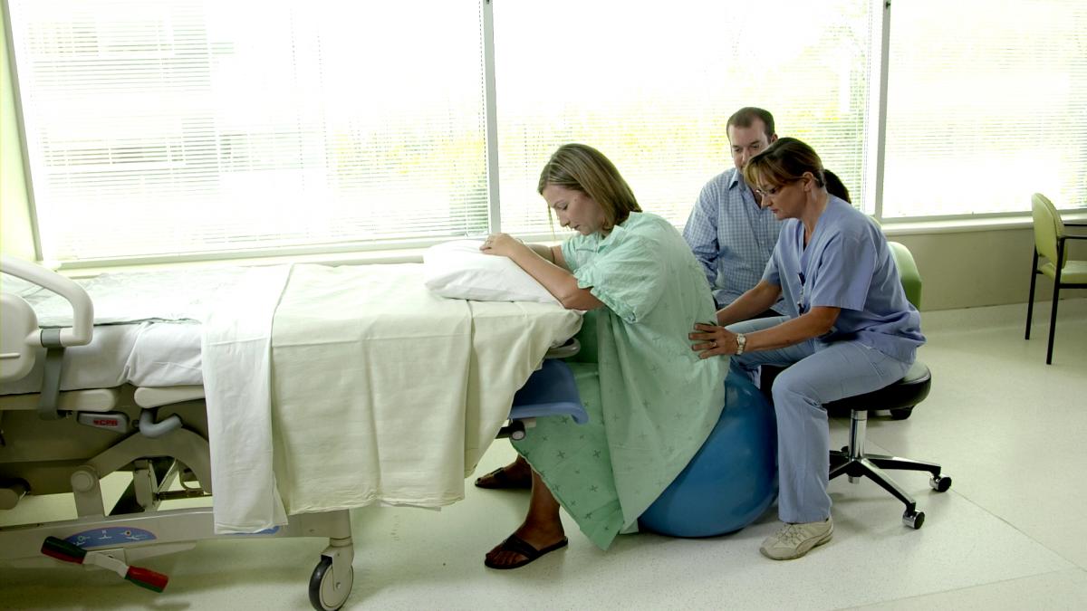 Femme en travail entourée de son équipe de soins