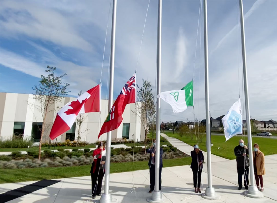 Plan large de quatre personnes qui hissent les drapeaux sur quatre mats