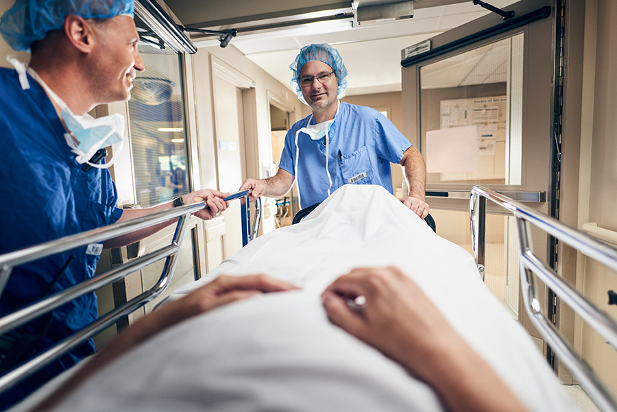 Médecin qui déplace un lit d'hôpital vu par le patient étendu