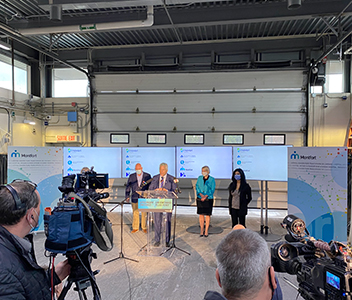 Groupe de personnes devant les cameras lors d'une présentation dans un hangar