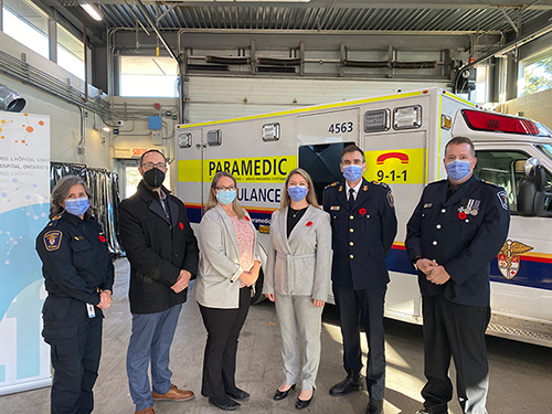 Medium shot of program representatives in front of an ambulance