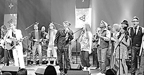 Musicians on stage surrounded by Franco-ontarian flags